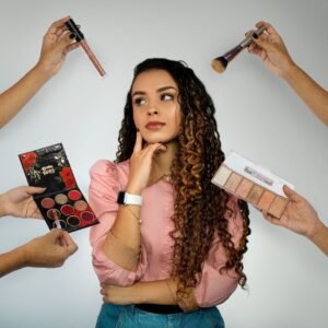 Stylish woman in pink surrounded by makeup tools, concept of beauty and fashion.